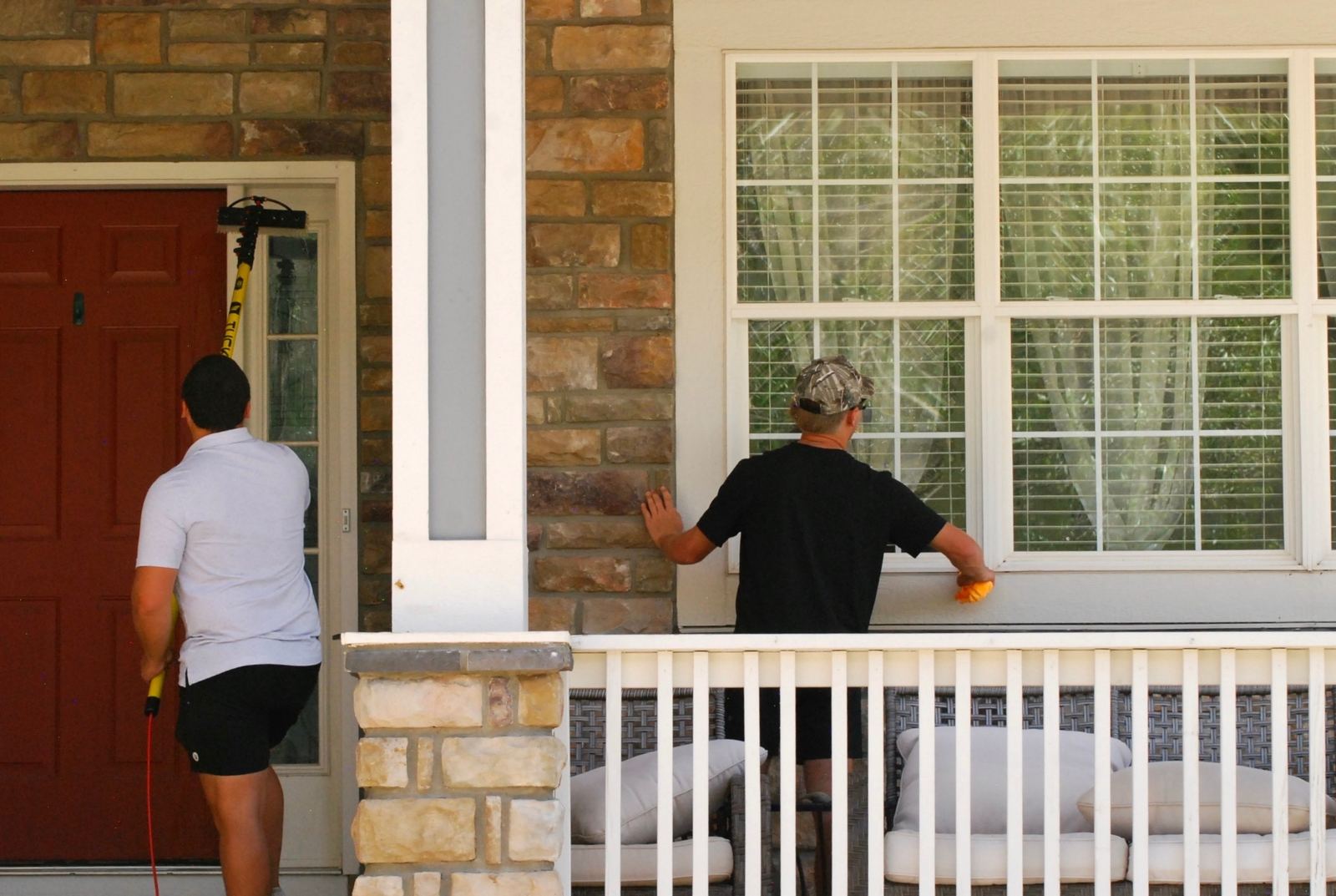 Two-person Prime Home Windows crew working a covered front porch